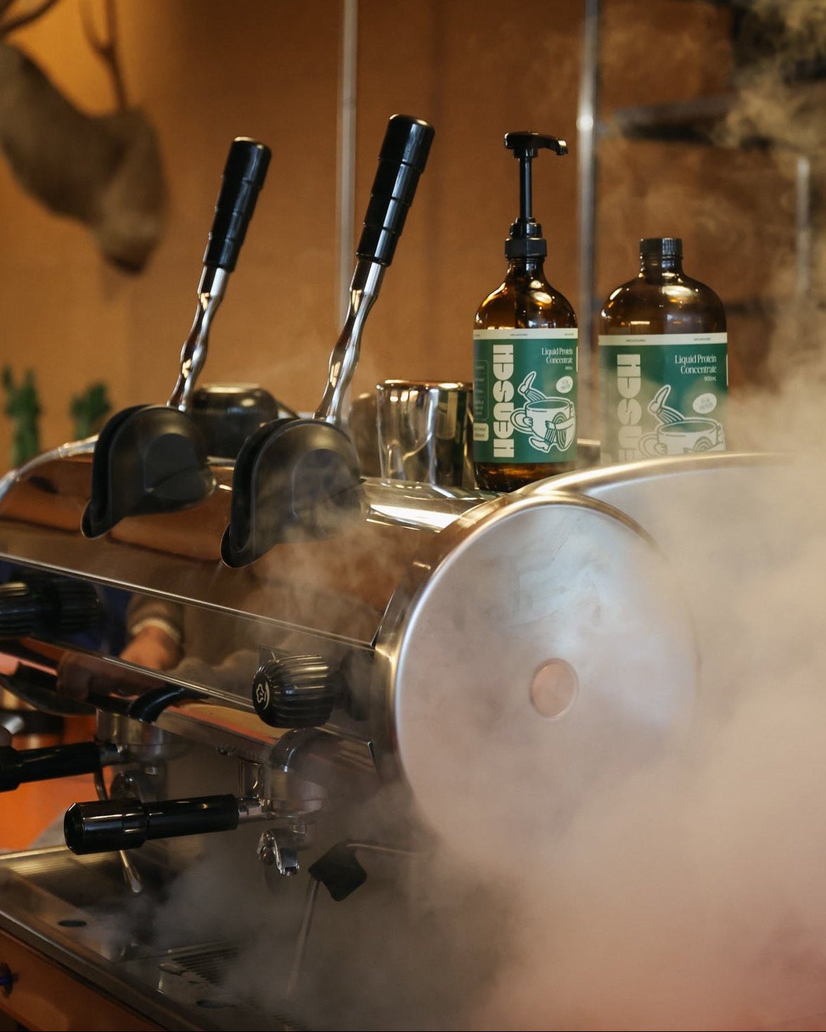 Hensch bottles behind the steam wand at a cafe